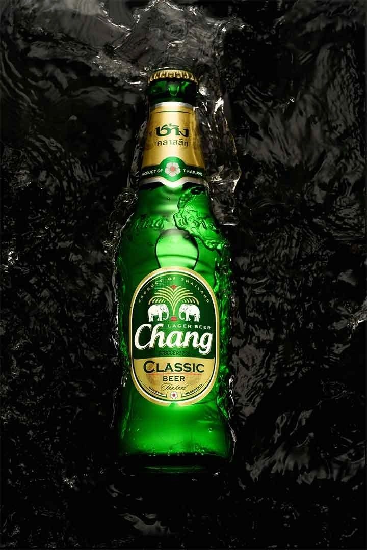 Hand holding a camera while capturing a liquor bottle image for marketing