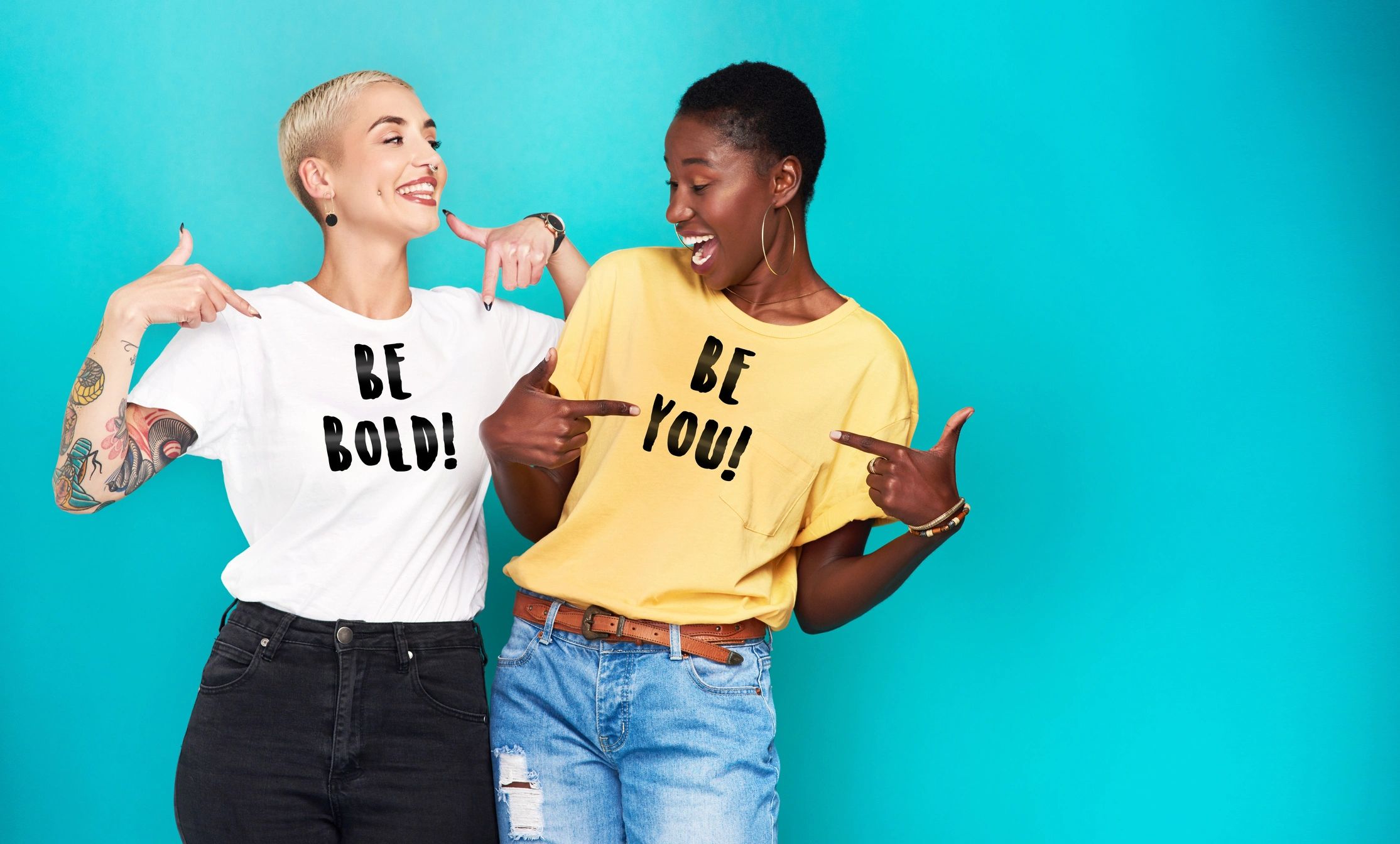 Two women wearing t-shirts looking at each other